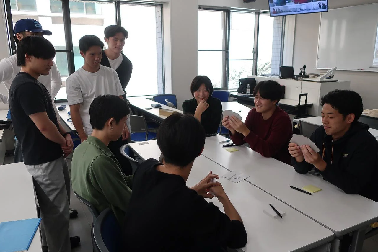 京都産業大学のシリアスゲーム開発プロジェクトで、カードを手にテストプレイする学生たち